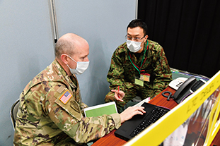米陸軍連絡チーム長と調整する筆者（右側）